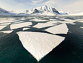 Landscape of dislocated pack ice with large patches of ice (called floe) in a surprisingly quadrangular shape in St Johnsfjord, island of Spitsbergen, Svalbard archipelago.