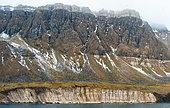 Mountain tundra landscape on the east coast of the island of Spitsbergen showing a dolerite inclusion between two layers of limestone, Svalbard archipelago
