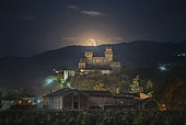 Moon setting over Torrechiara Castle, province of Parma, Emilia Romagna, Italy