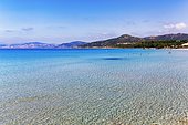 Turquoise blue clear water, coastline with hills on the horizon, L'Île-Rousse, Ile Rousse, Mediterranean Sea, Corsica, France, Europe