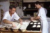 bakers filling up the baskets with the shaped dough