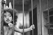 Brazil;Sao Paulo;Favela - A young girl looks out from her home in a favela, Sao Paulo.