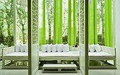 Wide seating area with lime green curtains viewed through screen door