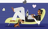 Hearts around man using laptop on chaise lounge