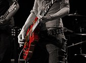 Playing a red electric guitar