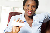 young woman shows a tube of ointment with a beautiful smile.