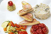 Presentation of a Mediterranean plate with fillets of red mullet, rice, tartlets with cherry tomatoes and colorful vegetables.
