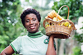 smiling young woman holding a basket of fruit in her hand and went for a picnic
