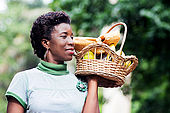 smiling young woman holding a basket of fruit in her hand and went for a picnic