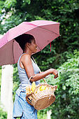 Young woman carrying a basket full of provisions.