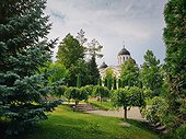 Curchi Monastery and beautiful outdoor garden view. The green park around the famous landmark in Orhei, Moldova. Christian Orthodox style church traditional for eastern Europe culture and religion