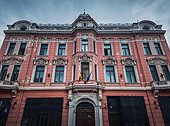 National Bank of Romania in Brasov old town, located in the Czell palace. Pink colored old building facade, traditional architectural style