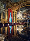 Dining room of Napoleon III at the Louvre Museum. Beautiful decorated royal family apartments, ornate with gold, mural paintings and crystal chandeliers suspended from ceiling