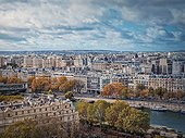 Paris cityscape over the Seine river, view from the Eiffel tower height, France. Fall season scene with colorful yellow trees