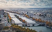 Aerial panorama of Paris city, France. Multiple bridges over the Seine river and vibrant colored autumn trees on the riverbank. Beautiful fall season cityscape panoramic view