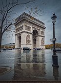 Triumphal Arch (Arc de triomphe) in Paris, France. Rainy autumn day with a romantic view to the historical landmark from the street, vertical background