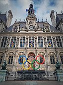 Close up Paris City Hall entrance. Outdoors view to the beautiful ornate facade of the historical building and the olympic games rings symbol in front of the central doors, as France host in 2024