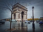 Triumphal Arch (Arc de triomphe) in Paris, France. Rainy autumn day with a romantic view to the historic landmark from avenue