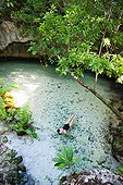 Young woman floating in lagoon, Grande Cenote, Quintana Roo, Tulum, Mexico
