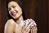 Young woman playing cards, holding royal flush