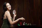 Young woman gambling with playing cards