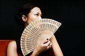Woman holding oriental fan, portrait
