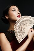 Woman holding oriental fan, portrait