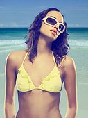 Young woman wearing yellow bikini and sunglasses