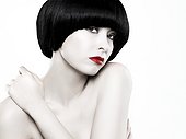Young woman with black bob touching shoulder