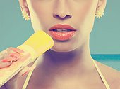 Young woman eating ice lolly