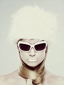 Young woman wearing white sunglasses and fur hat