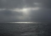 Sun shining through storm clouds over North Sea, Netherlands