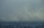 Storm clouds over industrial ship on sea