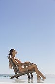 Beautiful woman sitting on a chair on the beach