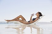 Beautiful woman drinking water on the beach