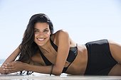 Beautiful woman in bikini lying on the beach and smiling