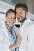 Portrait of a smiling couple in bathrobes at spa