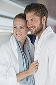 Close-up of a smiling couple in bathrobes at spa