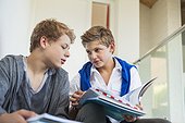 Two teenage boys studying in a school