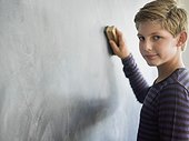Boy cleaning blackboard with a duster in a classroom
