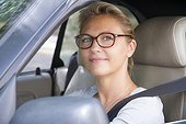 France, Paris, woman wearing glasses, smiling, driving a car