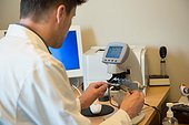 Male optometrist examining eye test equipment