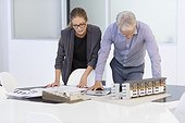 Design professionals examining architectural model in an office