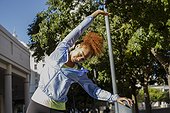 Young woman doing stretching exercise outdoors