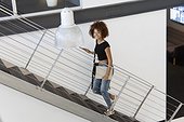 Portrait of a young woman moving up staircase