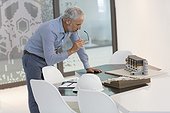 Design professional examining architectural model in an office