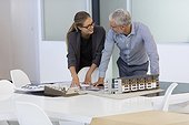 Design professionals examining architectural model in an office