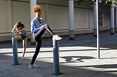 Young female athletes doing stretching exercise outdoors