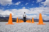 Man standing in-between two rows of safety cones