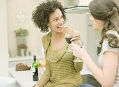 Women drinking wine in kitchen